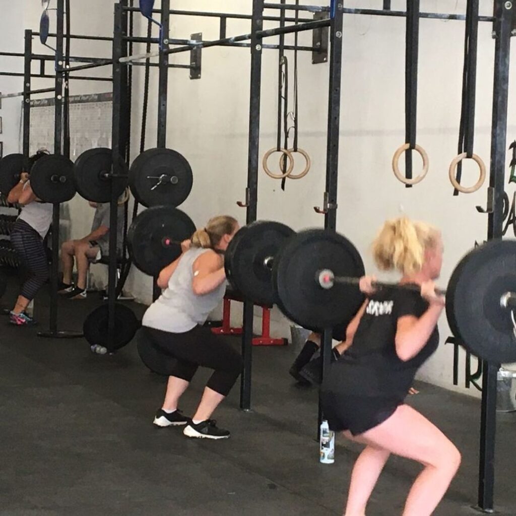 People doing squats with weight